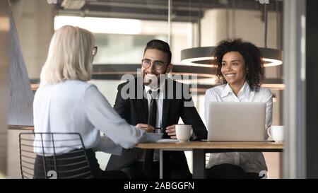 Smiling multiracial employers impressed by female applicant at interview Stock Photo