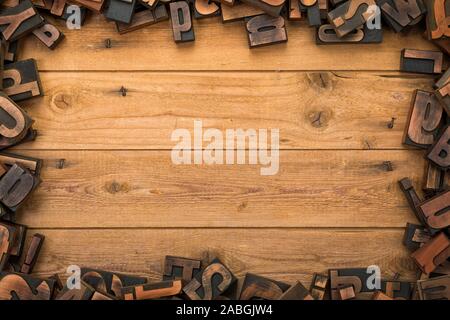 Rustic wood planks background with random vintage letterpress printing blocks frame Stock Photo