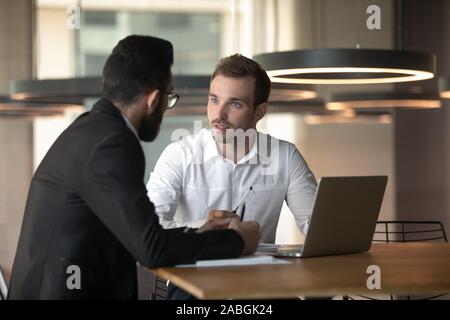Young businessmen cooperating using laptop in office Stock Photo