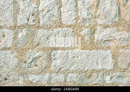 Light a fragment of a wall from limestone blocks of stone for use as abstract background or texture. Stock Photo