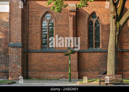 Two arched Windows with stained glass on the brick wall of the Cathedral of saints Peter and Paul in the old part of Kaunas. From the Windows of the w Stock Photo