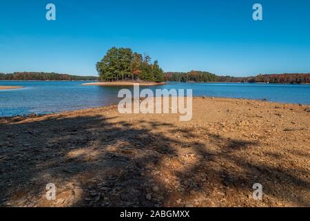 Erosion from drought conditions on the island and the lake shore at Lake Lanier, Georgia with the view of rocks exposed on the beach on a sunny colorf Stock Photo