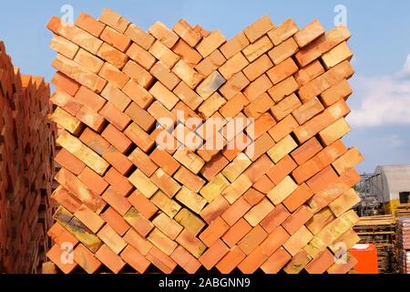 A pile of new bricks at construction site sitting on pallet Stock Photo ...