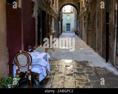 Table set up for romantic dinner for two in the narrow street of Venice, Italy. Concept of being ready for romantic date. Stock Photo