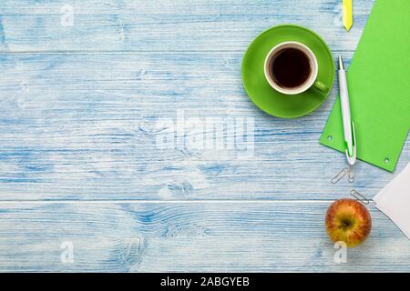 Desktop with coffee cup, apple, blank paper and utensils flat lay background with copy space Stock Photo