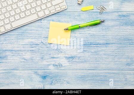 Desktop with computer keyboard, blank sticky paper and utensils flat lay background with copy space Stock Photo