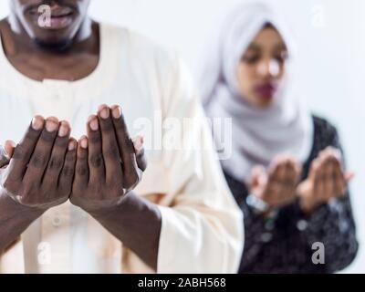 african muslim couple praying Allah by raising hands and making fatiha pray isolated on white background Stock Photo