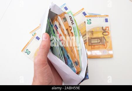 Picture showing envelope and piles of euro bills - Euro is the european currency - more or less in the new year 2020 Stock Photo
