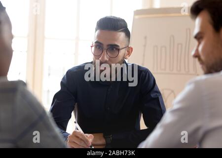 Middle eastern ethnicity young businessman listening to multiracial partners. Stock Photo