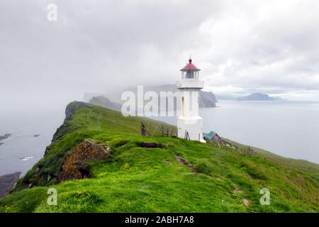 Foggy view of old lighthouse on the Mykines island, Faroe islands, Denmark. Landscape photography Stock Photo