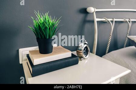 Bedside table with books and plant Stock Photo