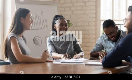 Overjoyed mixed race employees managers workers laughing at funny joke. Stock Photo