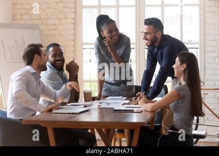 Cheerful mixed race young business partners enjoying break time. Stock Photo