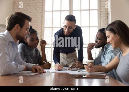 Engaged arabic male team leader discussing project ideas with partners. Stock Photo