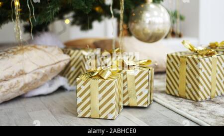 Gold boxes of presents under the Christmas tree Stock Photo
