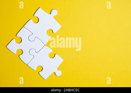 Three pieces of a puzzle united among themselves on a yellow background. Teamwork concept. Close up.
