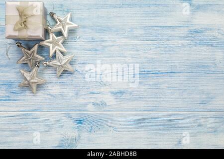 Silver christmas gift box and star decoration on rustic blue wooden background with copy space. Stock Photo