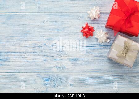 Christmas background with red and silver gift boxes and ribbon bow decoration, large copy space on blue rustic wood Stock Photo