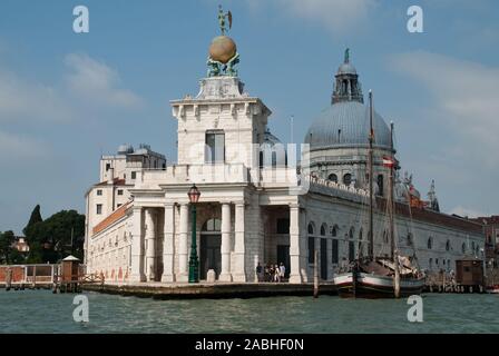 Venice, Italy: Sculpture atop the Dogana building, (Punta della Dogana), an art museum in one of Venice's old customs buildings, Church Santa Maria de Stock Photo