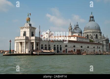 Venice, Italy: Sculpture atop the Dogana building, (Punta della Dogana), an art museum in one of Venice's old customs buildings, Church Santa Maria de Stock Photo