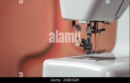 Sewing needle threader tool in use and a single black string Stock Photo -  Alamy