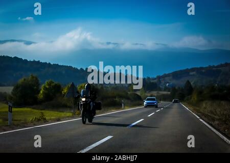 Front view of motorbikea and car driving on the two way road with landscape of Gorski Kotar in Croatia. Stock Photo