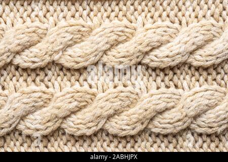 Beige Knitwear Fabric Texture with Pigtails. Beige Knitted Background. Stock Photo