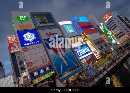 Osaka, Japan - March 21, 2017: Frontal yet crooked view of the Glico man and neon lighting on a canal in  Dotonbori, Osaka Stock Photo