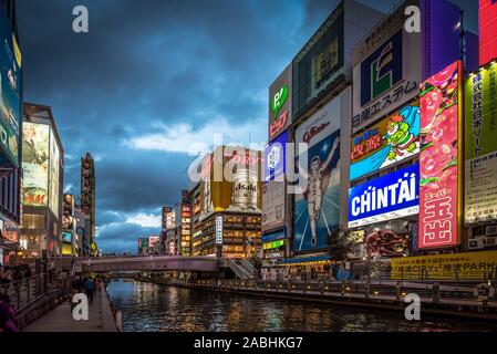 Osaka, Japan - March 21, 2017: Glico man and neon lighting on a canal with few people in  Dotonbori, Osaka Stock Photo