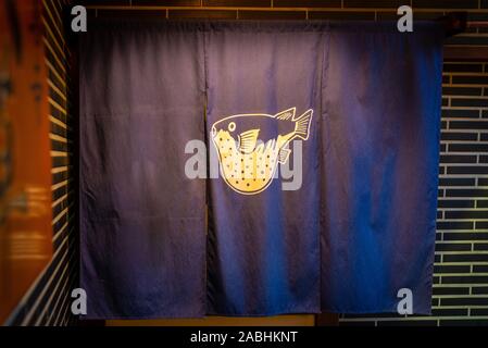 Osaka, Japan - March 21, 2017: Blowfish drawing on a blue curtain, taken in the evening with artificial light at the entrance of a restaurant in Osaka Stock Photo
