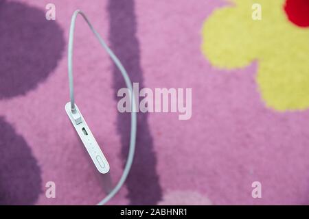 Energy bank . Smartphone Charging with silver Power Bank Through Spiral USB Cable . Smartphone charging with power bank on pink carpet . Stock Photo