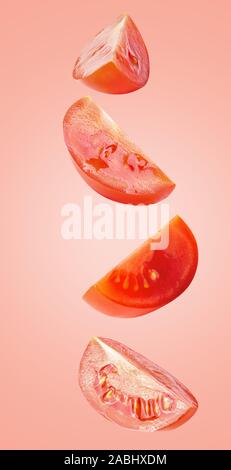 Floating tomatoes isolated on light coral background Stock Photo