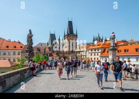Many tourists walk across Charles Bridge, Lesser Town Bridge Tower and Prague Castle, Prague, Bohemia, Czech Republic Stock Photo