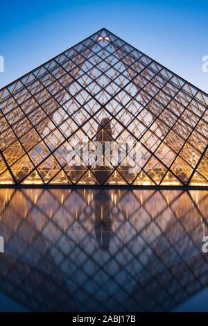PARIS, FRANCE - JULY 6: The Louvre Pyramid at dusk during the Michelangelo Pistoletto Exhibition on July 6, 2013 in Paris