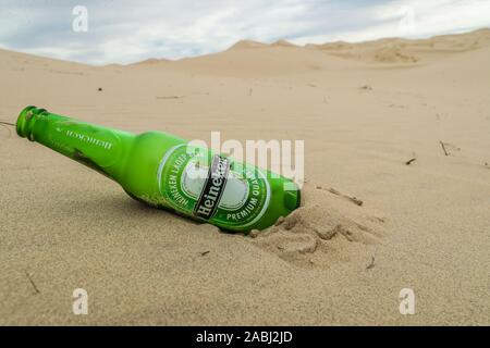 glass bottle, Heineken Pilsener beer. green bottle pollution and garbage in the sand dunes of the Samalayuca desert, Chihuahua Mexico. 52 km south of Stock Photo