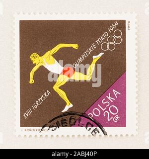 SEATTLE WASHINGTON - October 9, 2019: Polish Olympics stamp with running athlete and copy space, commemorating 1964 Tokyo Games. Stock Photo