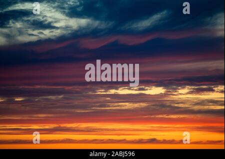 Multicolored dramatic Stratocumulus clouds at sunset. Stock Photo