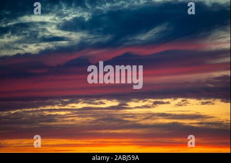 Multicolored dramatic Stratocumulus clouds at sunset. Stock Photo