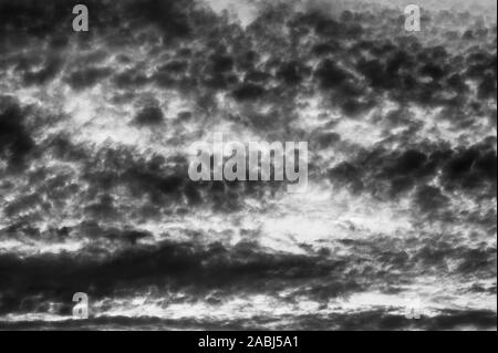 Altocumulus Perlucidus clouds toward sunset in dramatic sky, black and white image. Stock Photo