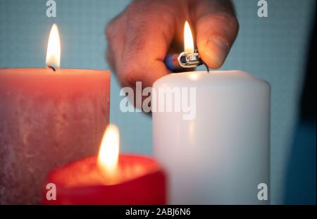 Stuttgart, Germany. 21st Nov, 2019. A man lights a candle. (about dpa: 'Lifestyle product for dirty weather - candle industry is looking for the niche') Credit: Marijan Murat/dpa/Alamy Live News Stock Photo