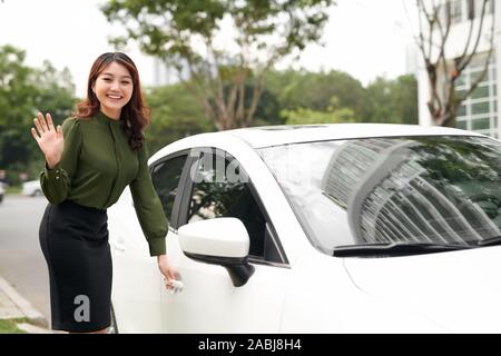 Beautiful Asian Woman Smiling and Open the Car Door Ready For Driving Stock Photo