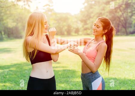 Sport exercise personal trainer teaching student to warm up and stretching her arm and shoulder. Stock Photo