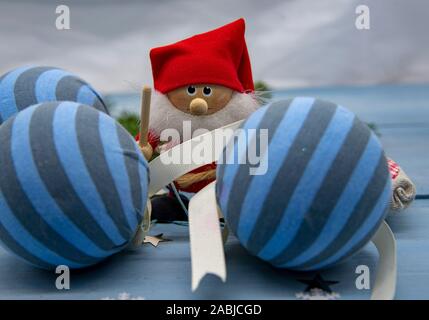 Santa Claus between striped Christmas balls and fir branches Stock Photo