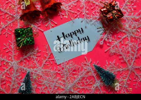 Happy Birthday write on label with Pink backgroud. It means Best Wishes. Frame of Christmas Decoration. Stock Photo