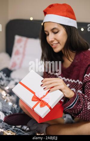 Curious woman looking at her opened Christmas present Stock Photo