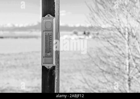 Vintage analog outside thermometer in a black and white photo in winter Stock Photo