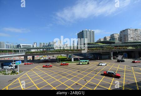 Red Taxis crossing a busy intersection in West Kowloon, Hong Kong. Stock Photo