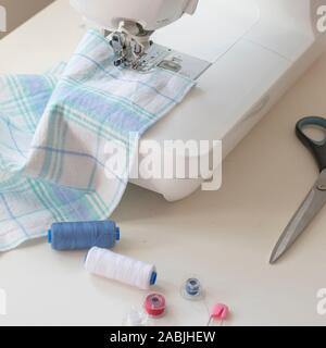Sewing machine part, fabric, threads and accessories for sewing close-up Stock Photo
