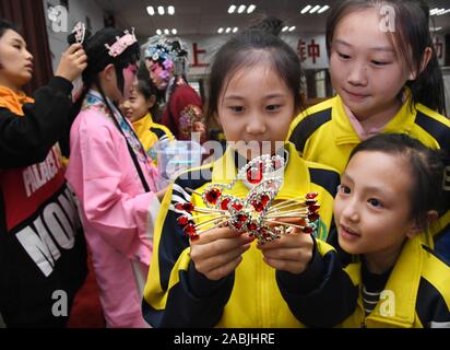 Qingdao, China's Shandong Province. 27th Nov, 2019. Students from Peking Opera club view a headwear of Peking Opera at Tongji Experimental School in Qingdao, east China's Shandong Province, Nov. 27, 2019. Nearly 100 schools in Qingdao have established Peking Opera interest groups or clubs to develop students' sense of arts and inherit the traditional Chinese culture. Credit: Li Ziheng/Xinhua/Alamy Live News Stock Photo