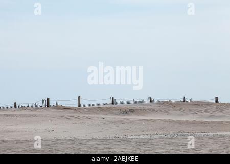 Sand dunes and a partially buried sand fence on the Atlantic coast of Assateague Island, Maryland, USA. Assateague Island National Seashore. Stock Photo